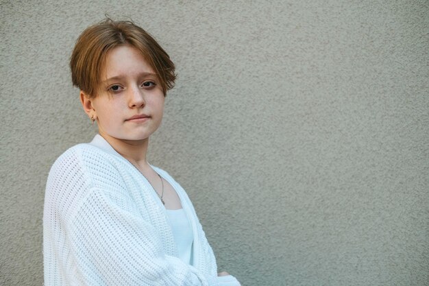 Les cheveux roux courts d'une adolescente contrastent avec une expression sereine dans un portrait qui capture l'essence de la jeunesse.