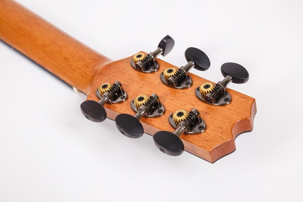 Chevilles de réglage sur la tête de la machine en bois de guitare six cordes sur fond blanc