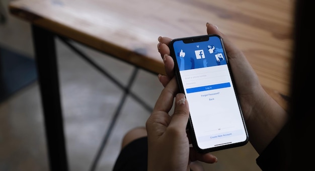 CHIANG MAI THAÏLANDE JUN 1 2022 Femme tenant un iPhone X avec le service Internet social Facebook sur l'écran