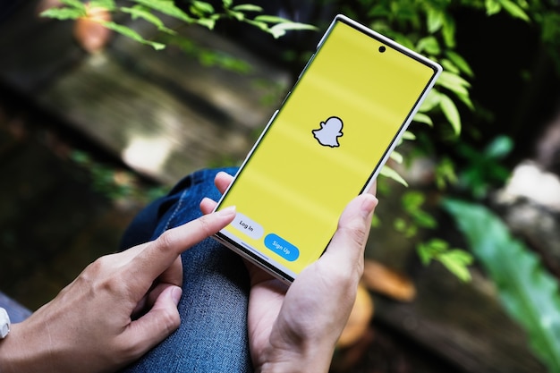 CHIANG MAI, THALANDE - 9 JUILLET 2021 : une main tenant un smartphonei mobile qui affiche l'application Snapchat.