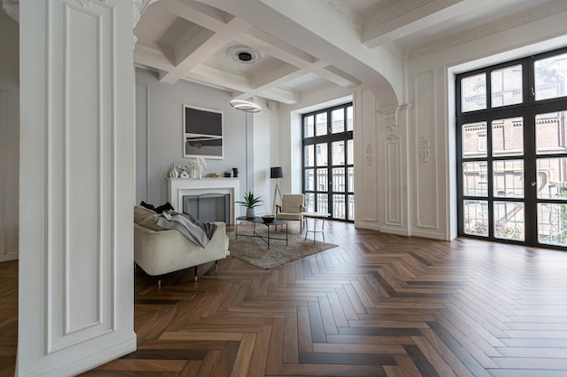 un chic intérieur lumineux coûteux d'un énorme salon dans un manoir historique avec des arches voûtées, des colonnes et des murs blancs décorés d'ornements et de stuc