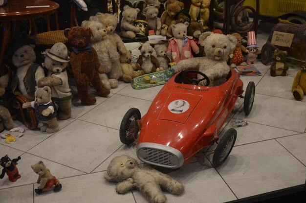 Un chien assis sur une voiture de jouet à un stand du marché