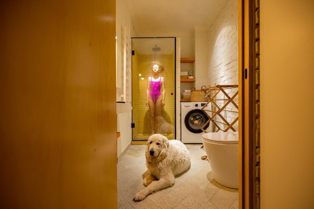 Chien avec une femme dans la salle de bain