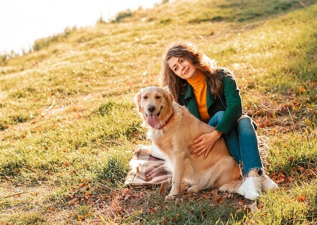 Chien Golden retriever avec une femme bouclée à l'extérieur aux beaux jours