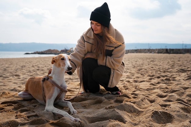 Photo chien greyhound avec femme propriétaire à la plage