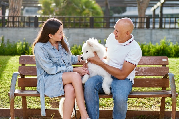 Photo chien samoyède avec sa femme propriétaire au parc jouant ensemble