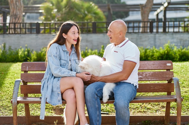 Photo chien samoyède avec sa femme propriétaire au parc jouant ensemble