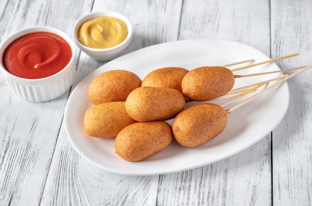 Chiens de maïs avec trempette sur assiette blanche