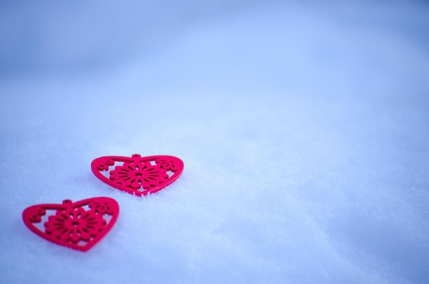 Chiffres en bois de coeurs rouges sur fond de neige ce soir