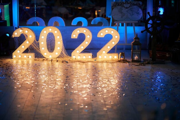 chiffres décoratifs 2022 en blanc avec lampes à incandescence sur fond bleu foncé