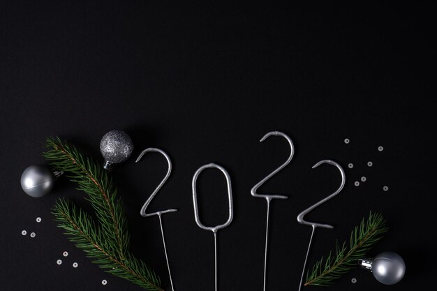 Photo chiffres pour la nouvelle année 2022 à venir avec des cordes de sapin et des boules de noël en argent