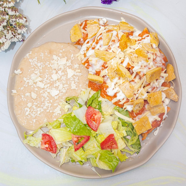 Photo chilaquiles avec purée de haricots et salade, vue cenital