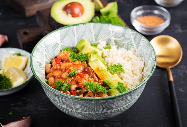 Chili con carne et couscous dans un bol sur fond sombre. Gastronomie mexicaine.