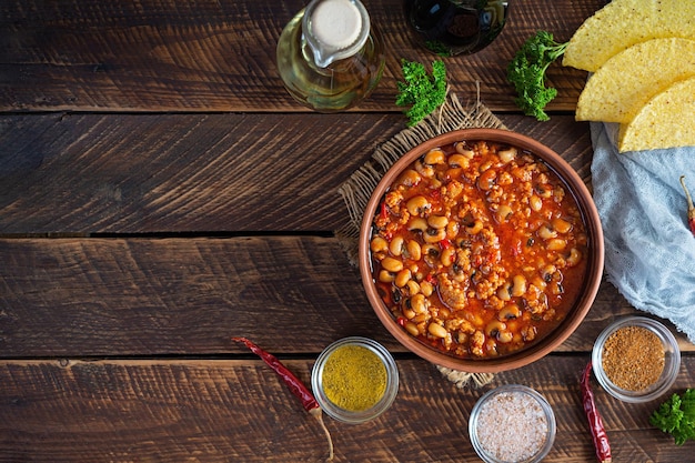 Chili con carne dans un bol sur fond de bois Cuisine mexicaine Vue de dessus