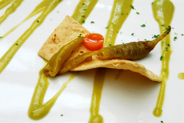 Photo chili guero totopo ou tostada avec chili guero couvert de sauce verte détail ou vue rapprochée de la nourriture