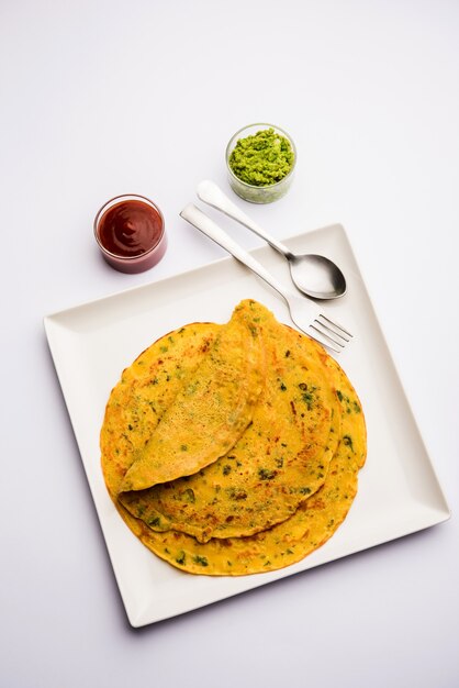 Chilla ou Besan cheela est une simple crêpe à base de farine de pois chiches et de quelques ingrédients de base servie avec du chutney vert et de la sauce tomate, également connue sous le nom d'omelette aux légumes