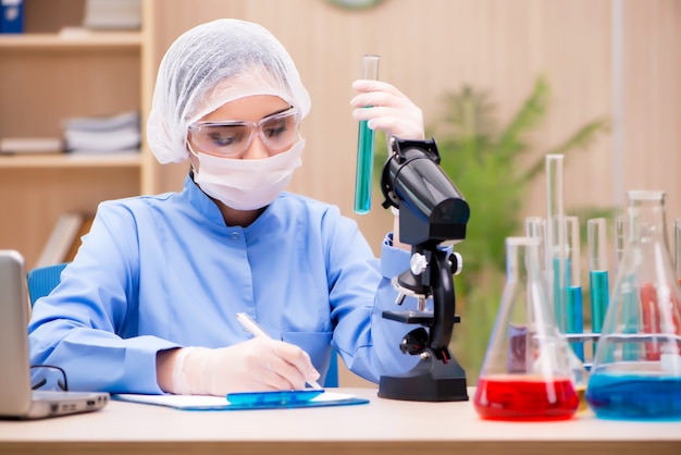 Chimiste de laboratoire travaillant avec un microscope et des tubes