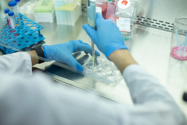 Un chimiste portant des gants de protection effectuant une expérience scientifique dans un laboratoire