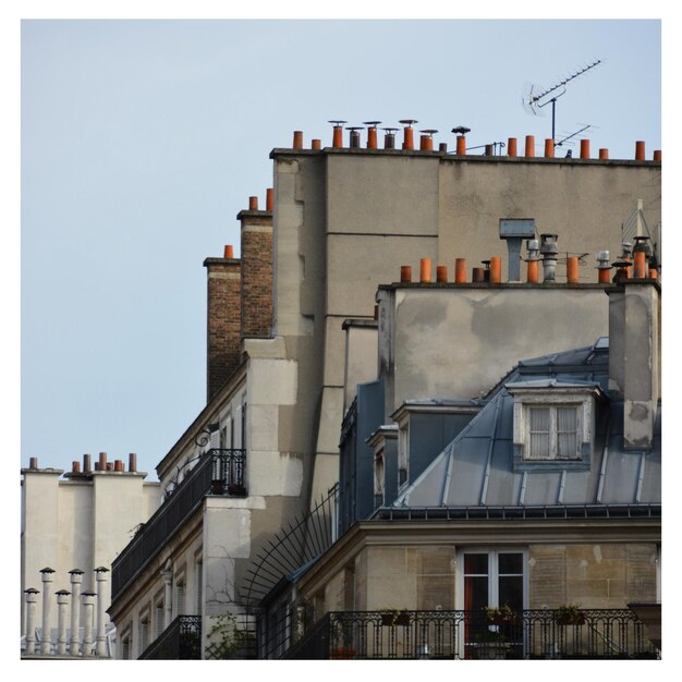 Photo chimneys sur les toits des maisons contre le ciel en ville