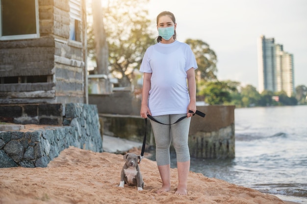 Chiot intimidateur américain drôle sur la plage avec des gens masque de voyage en famille nouvelle normalité