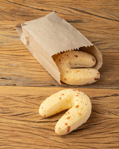 Chipas, petit pain au fromage sud-américain typique dans un sac en papier sur une table en bois.