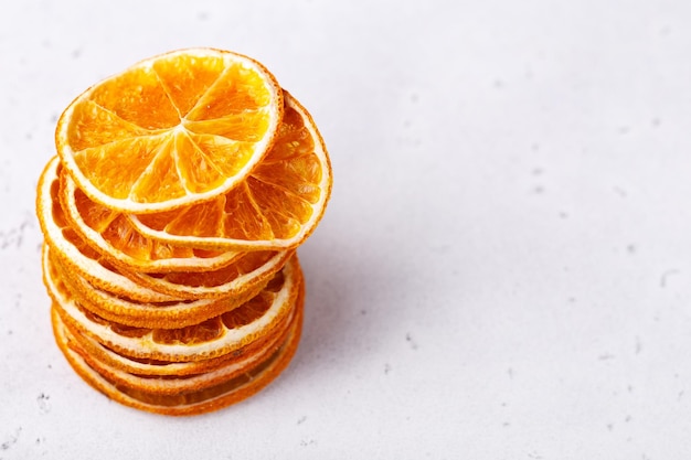 Photo chips de fruits orange sur fond de pierre blanche