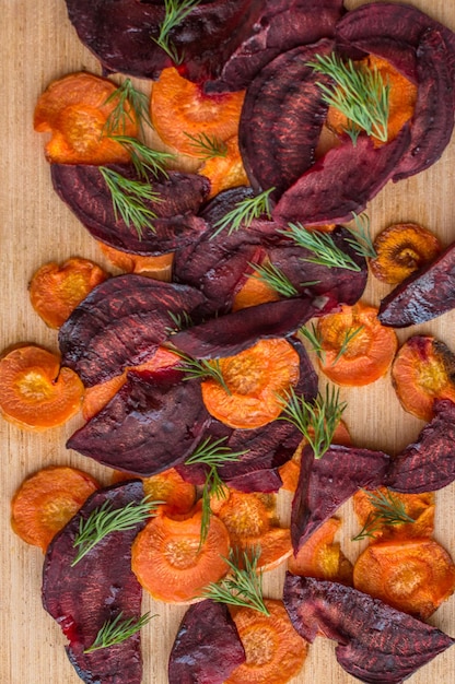 Chips de légumes de carottes et betteraves avec gros plan de verts