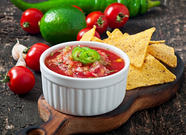 Chips de nacho mexicain et trempette de salsa dans un bol sur fond de bois