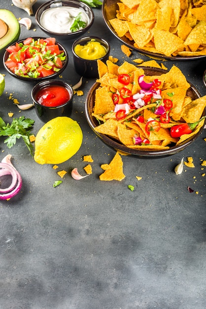 Chips de nachos avec diverses trempettes, snack mexicain traditionnel sur plaque