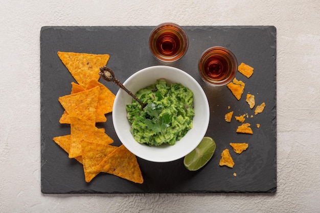 Chips de nachos avec guacamole et shots de tequila foncée ou de whisky