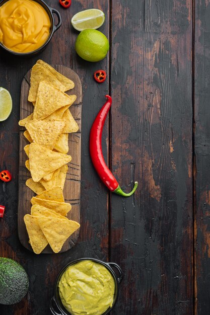 Chips de nachos mexicains avec fromage et sauces guacamole, sur la vieille table en bois