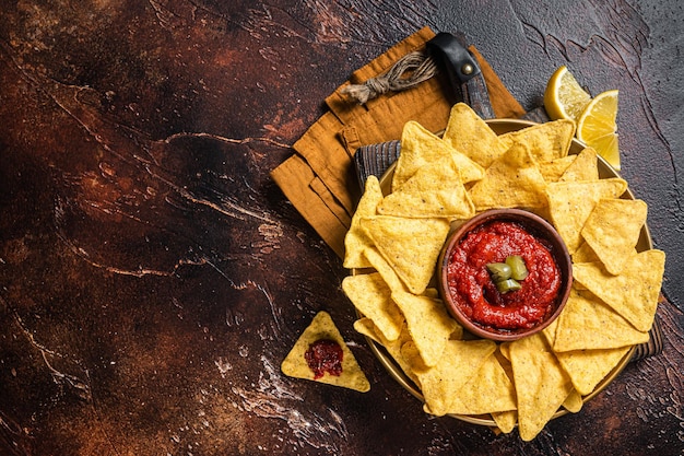 Chips de nachos avec sauce tomate et apéritif mexicain jalapeno Fond sombre Vue de dessus Espace de copie