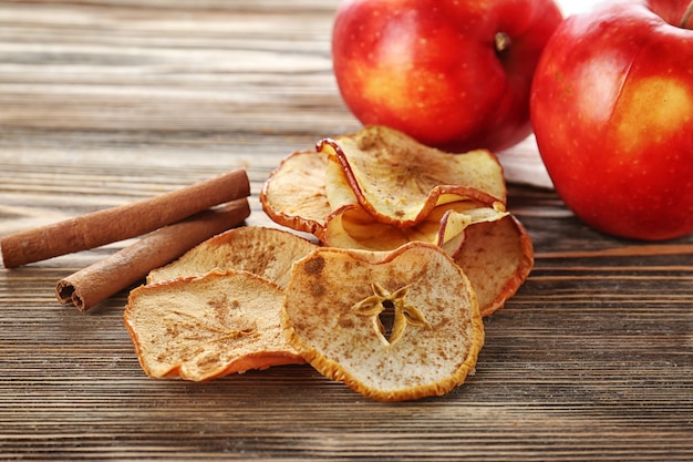 Photo des chips de pommes et des bâtons de cannelle sur une table en bois.