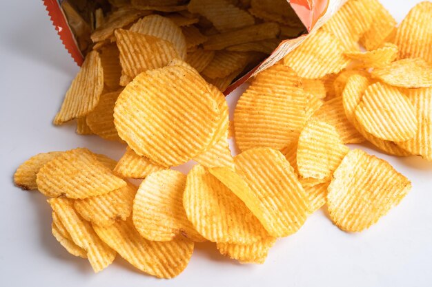 Photo des chips de pommes de terre délicieuses, des assaisonnements de barbecue, des épices pour les crips, des tranches minces, des friandises, des collations, des fast-foods dans un sac ouvert.