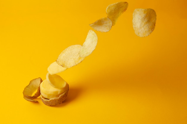 Chips de pommes de terre volent sur fond jaune