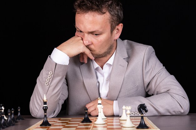 Échiquier avec homme d'affaires pensant à la stratégie d'échecs