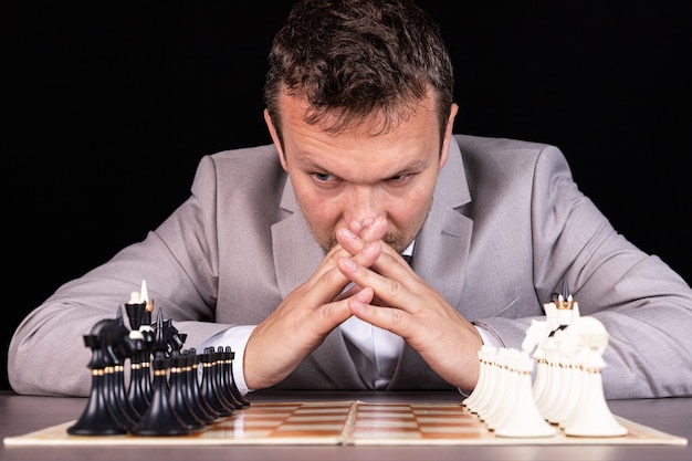 Échiquier avec homme pensant à la stratégie d'échecs