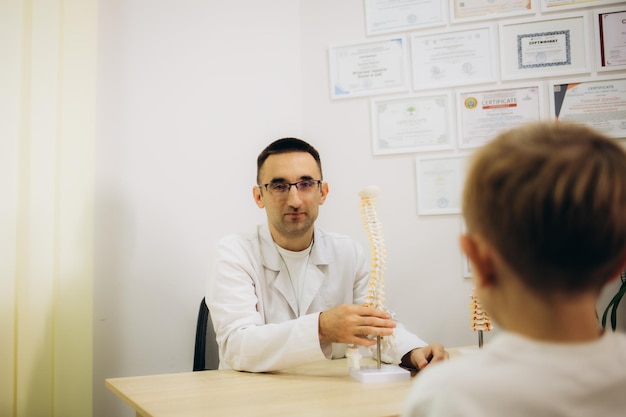 Un chiropraticien pédiatrique examine la posture des filles en gros plan, vue latérale, un physiothérapeute examine la colonne vertébrale.