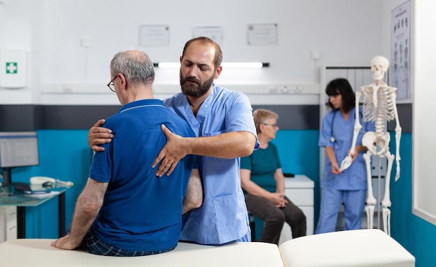 Chiropraticien traitant un patient retraité souffrant de maux de dos