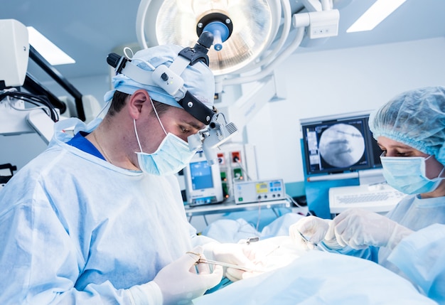 Chirurgie de la colonne vertébrale. Groupe de chirurgiens en salle d'opération avec équipement de chirurgie.