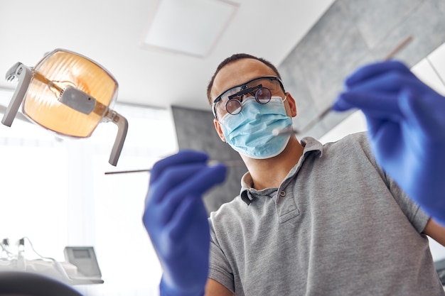 Chirurgie dentaire moderne, visage d'une femme médecin travaillant sur un patient. Opération d'implantation dentaire sur un patient au cabinet dentaire.