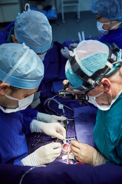 Un chirurgien avec des assistants effectue une opération dans un hôpital moderne. Équipe médicale effectuant l'opération.