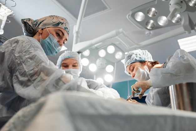 Chirurgien de l'équipe au travail en salle d'opération.