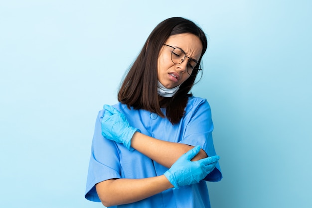 Chirurgien femme sur mur bleu avec douleur au coude