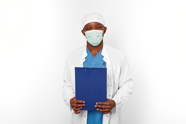 Photo chirurgien noir médecin homme en blouse blanche et masque de chirurgien détient des dossiers médicaux avec diagnostic