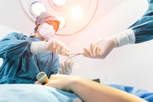 Photo chirurgien opérant un patient avec un assistant dans la salle d'opération concept de chirurgie et d'urgence