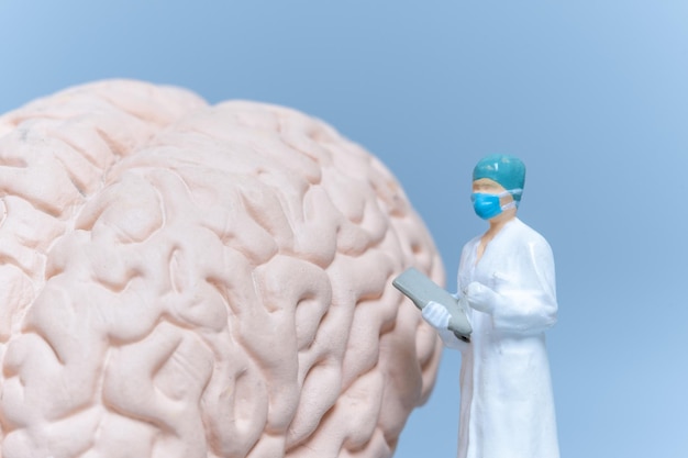Chirurgien de personnes miniatures analysant le cerveau du patient
