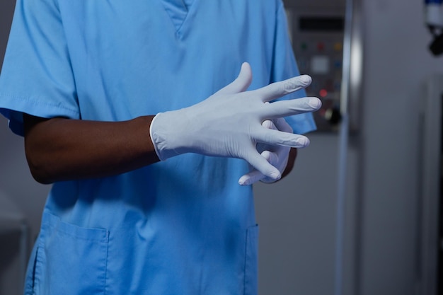 Photo chirurgien portant des gants chirurgicaux dans la salle d'opération de l'hôpital