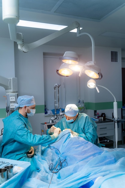 Chirurgien professionnel travaillant dans un service moderne. Couple en uniforme médical faisant de la chirurgie.