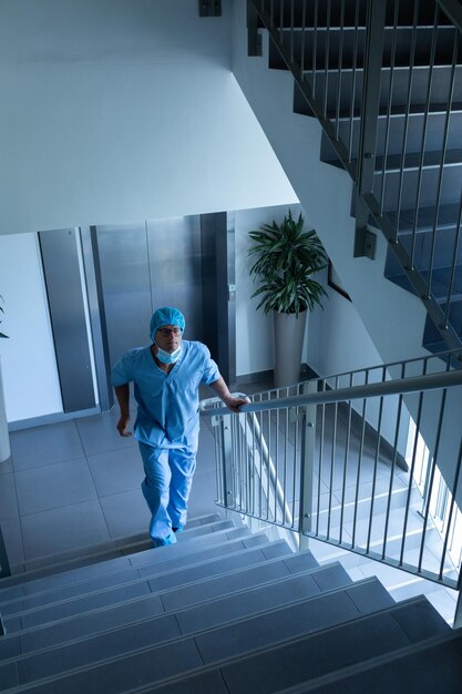 Photo un chirurgien qui monte les escaliers de l'hôpital.